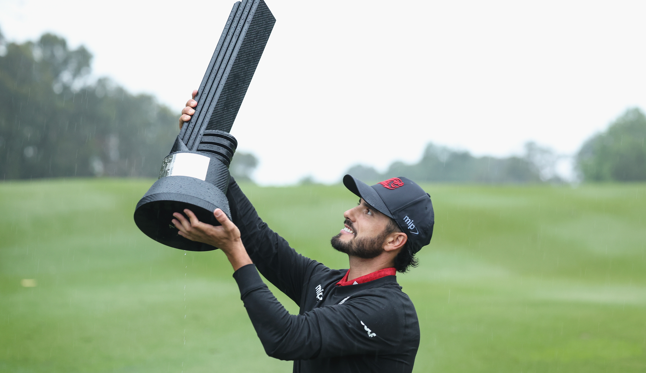 Abraham Ancer lifts the LIV Golf Hong Kong trophy in the air
