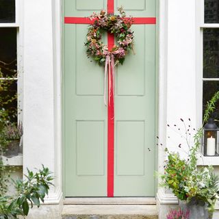 Wreath on green door with red ribbon