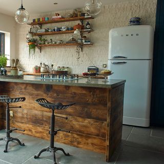 kitchen with wooden worktop and white fridge