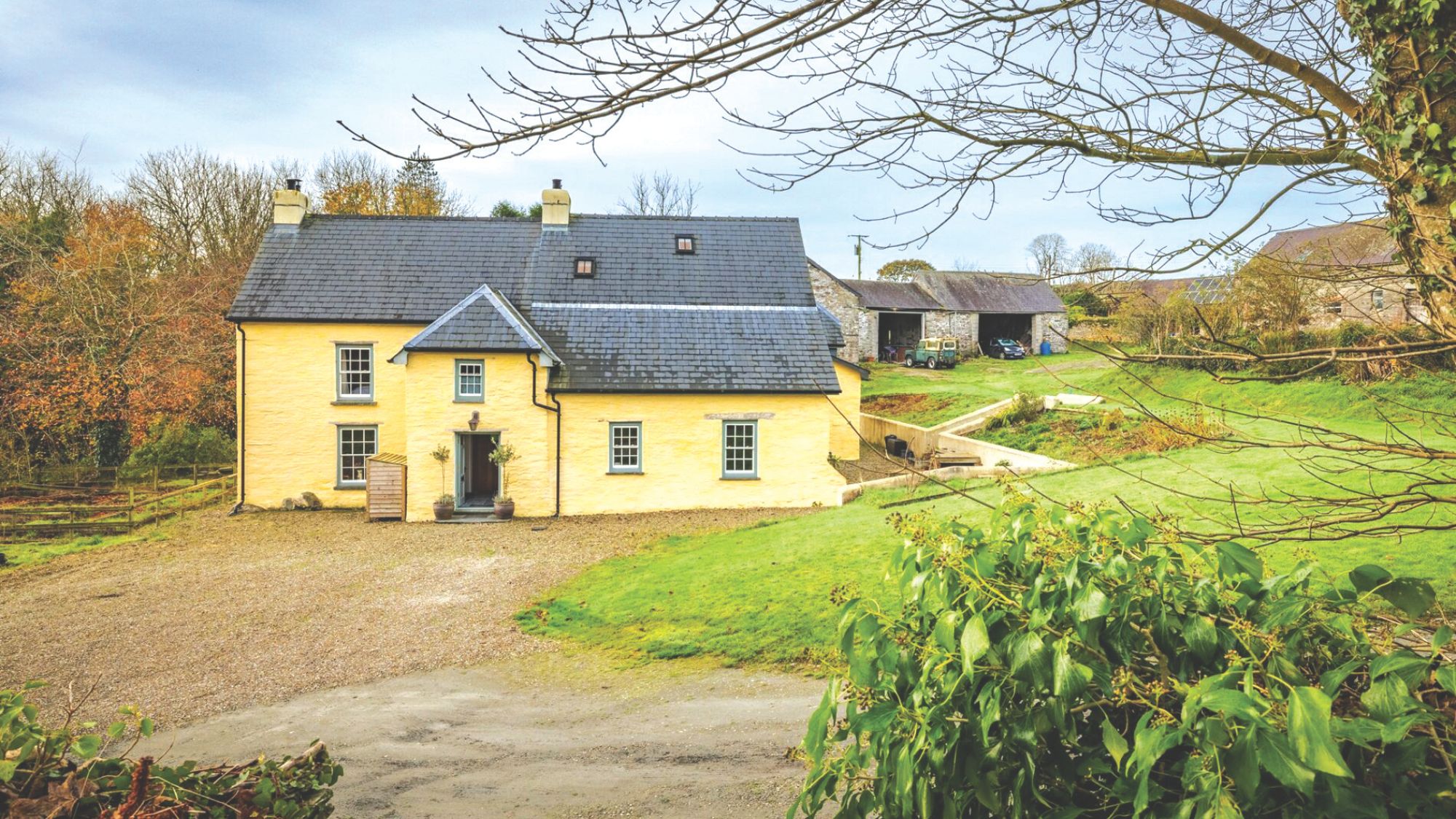 House surrounded by land with native broadleaf woodland and pasture
