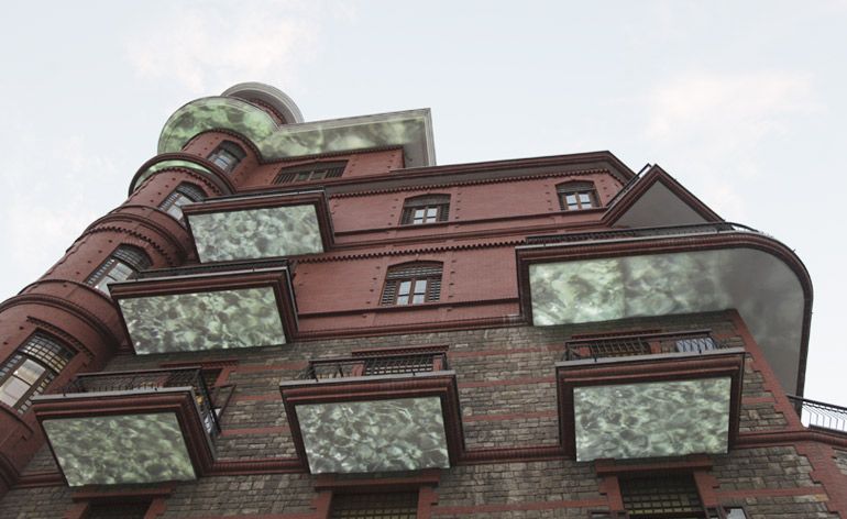 A view looking up from the street to the undersides of balconies where screens have been installed