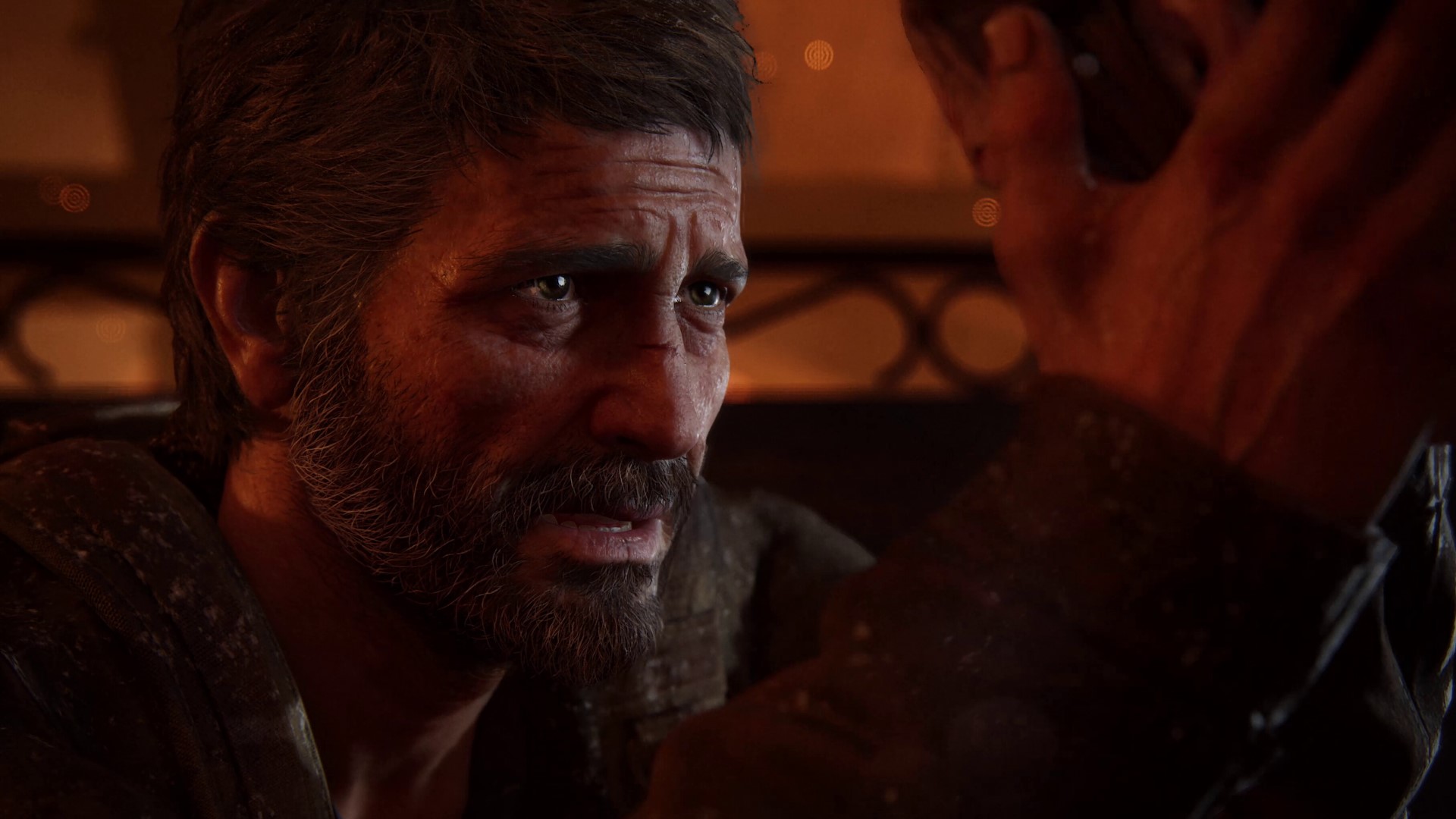 Joel holds his daughter's face as fire burns in the background