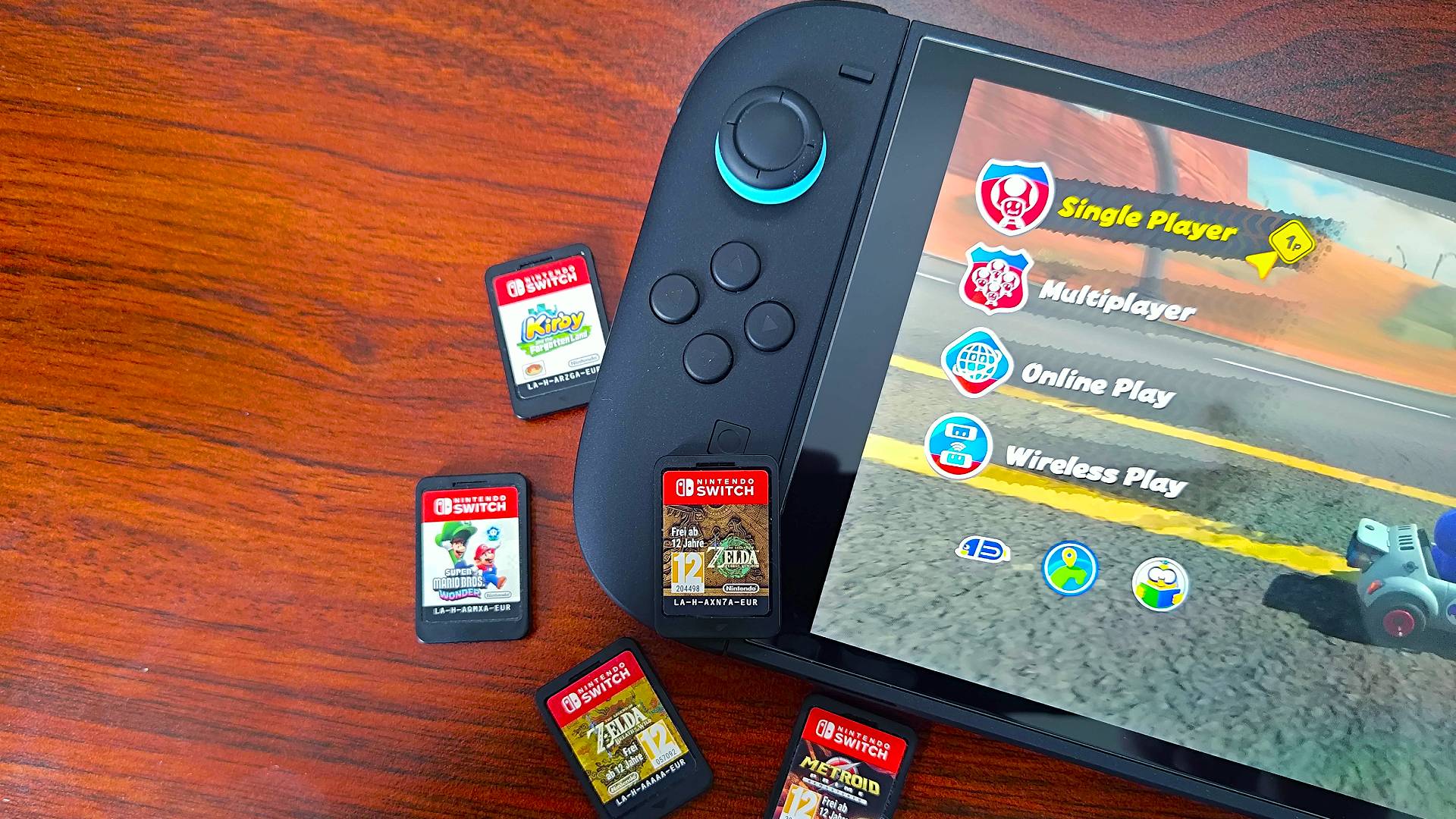 Close up of Nintendo Switch 2 on woodgrain desk next to cartridges.