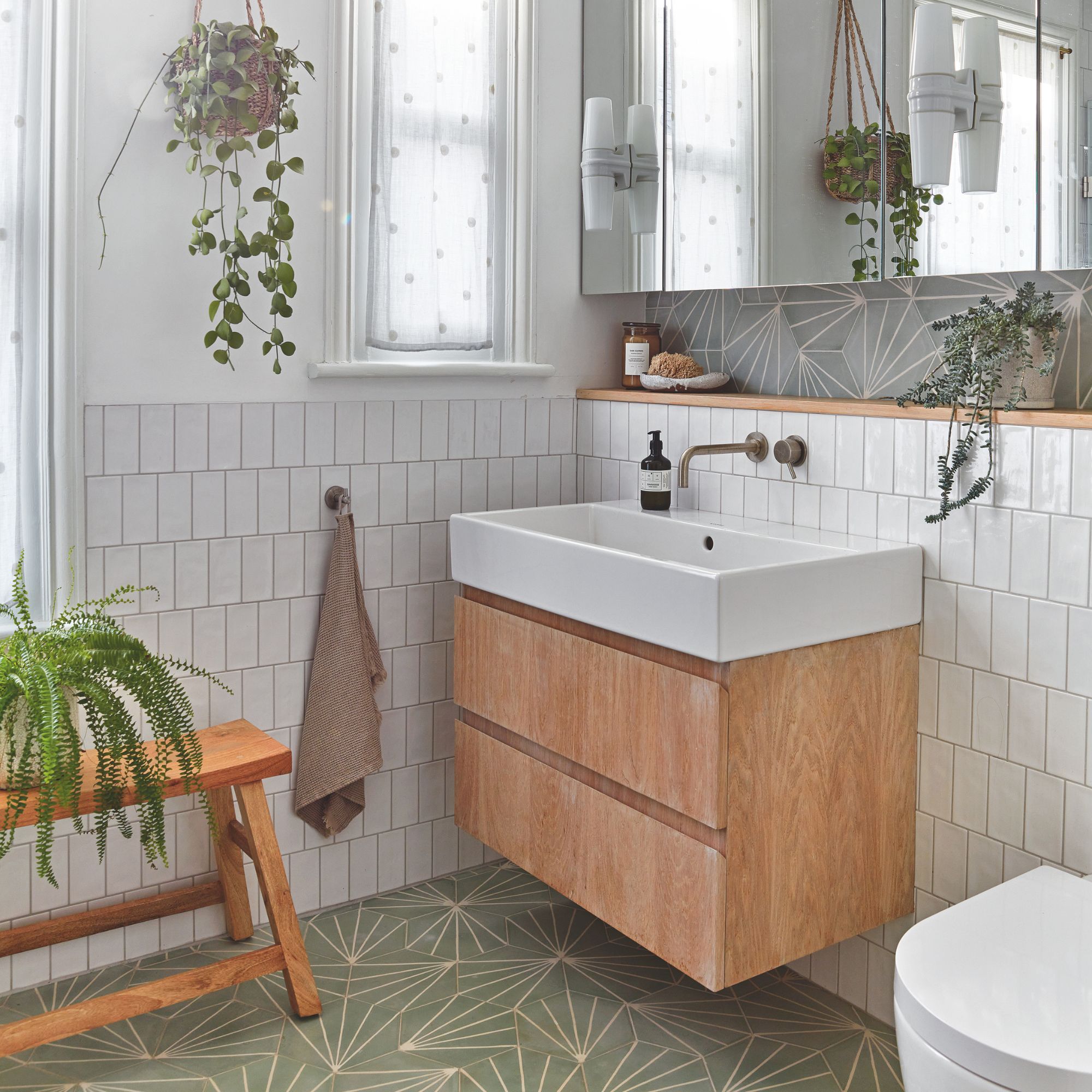 White painted and tiled bathroom with green tiled floor and a wooden sink vanity unit