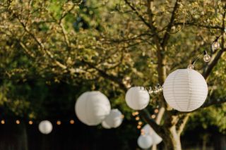 paper lanterns and festoon lights at backyard wedding