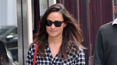 Pippa Middleton walking down the road wearing a checked shirt, jeans and red shoes