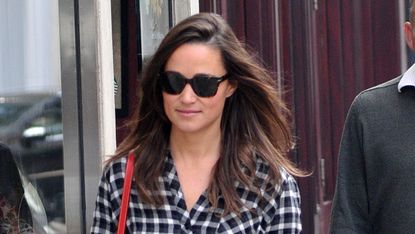 Pippa Middleton walking down the road wearing a checked shirt, jeans and red shoes