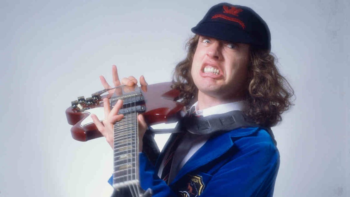 AC/DC’s Angus Young holding a guitar