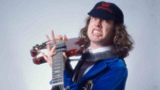 AC/DC’s Angus Young holding a guitar