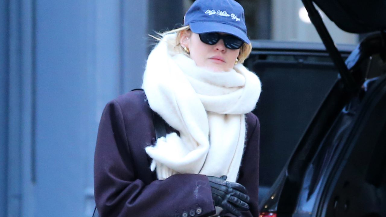 Gigi Hadid walks in Manhattan wearing an extra oversize scarf with a purple longline coat and leather gloves