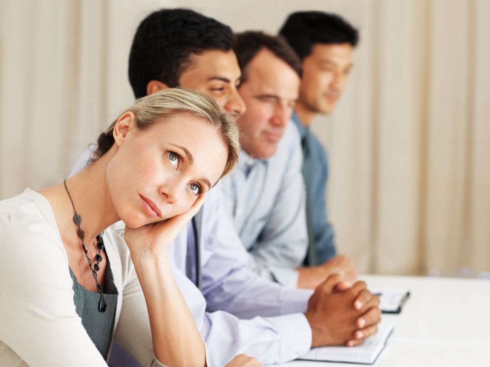 Woman daydreaming in an office meeting