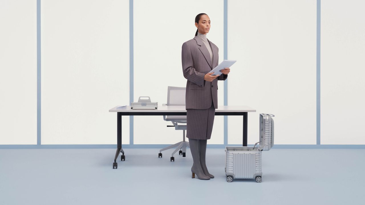 Woman wearing a suit stands next to an open aluminium storage box