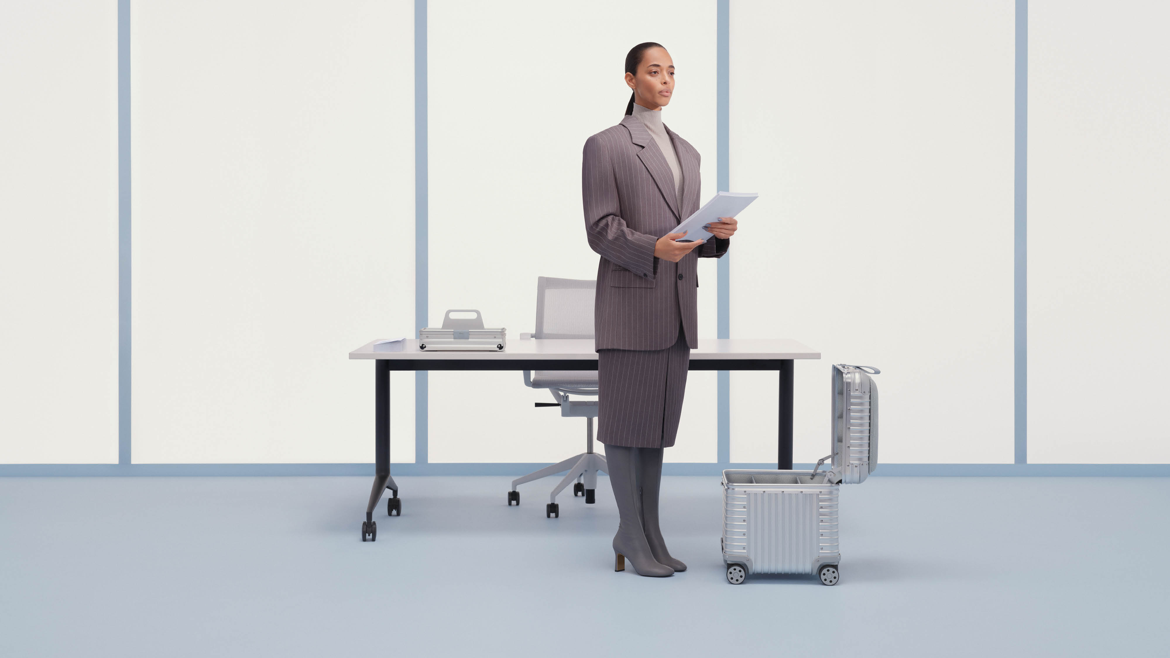 Woman wearing a suit stands next to an open aluminium storage box
