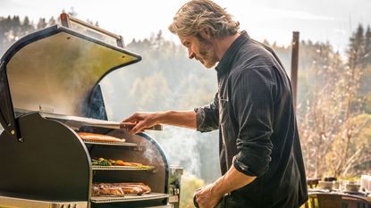 男子烹饪食物Traeger Timberline 1300颗粒烧烤