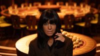 Claudia Winkleman poses in front of the Round Table for The Traitors season 2