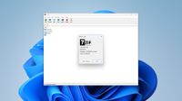 A screenshot of 7-Zip with its About window open, showing version 26.02 which fixes a vulnerability.