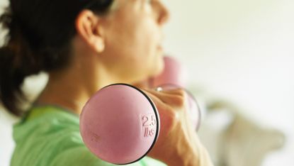 Woman training with light dumbbells