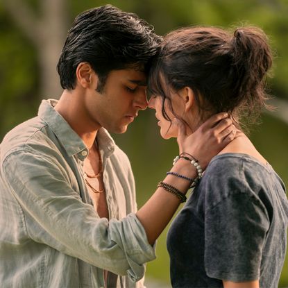 A teenage boy holds a teenage girl's neck as they almost kiss, in 'We Were Liars.'