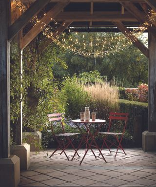 A 2-person patio bistro dining set with outdoor string lights