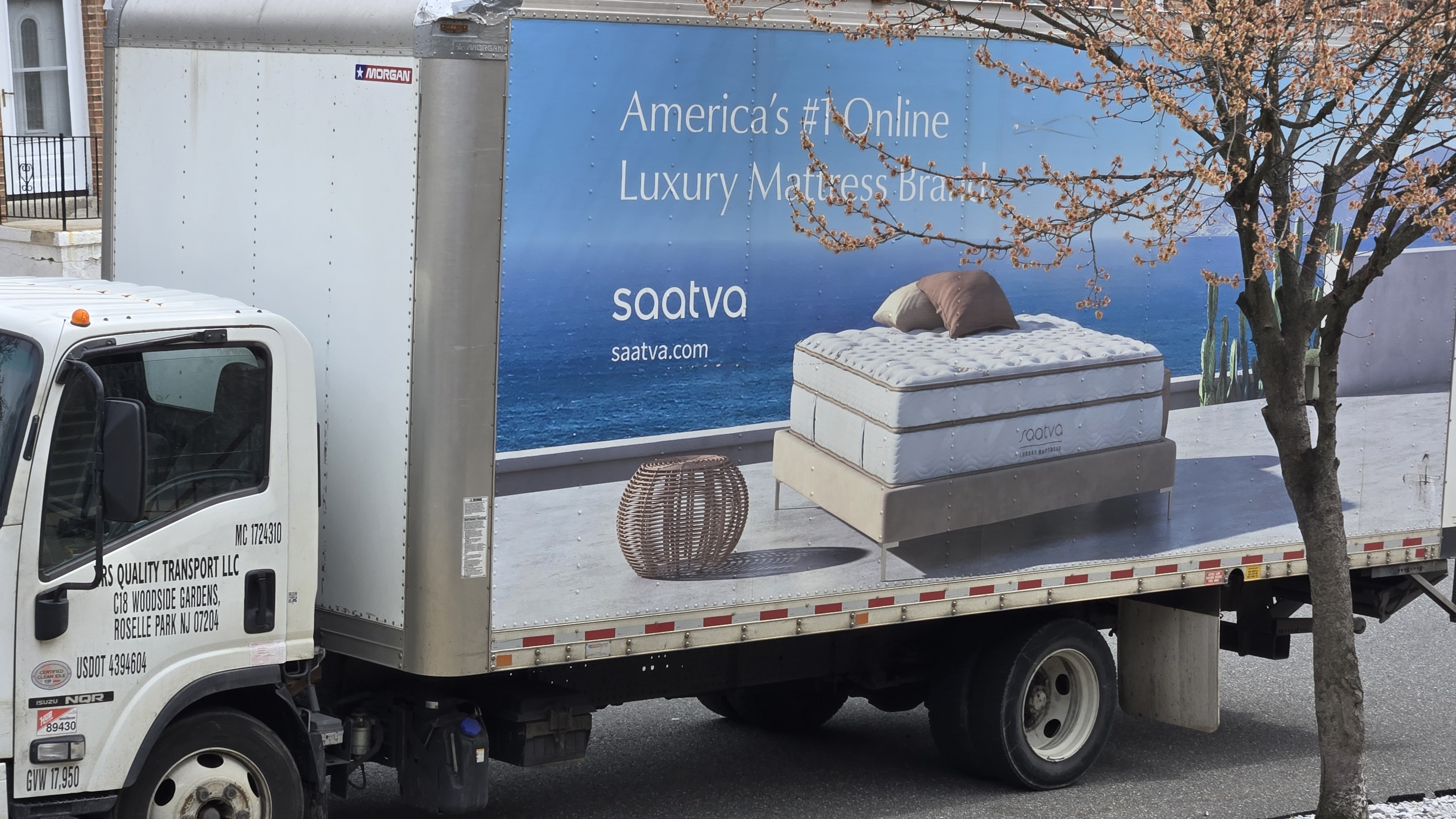 A Saatva delivery truck parked in front of our tester's home