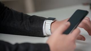 A person uses a Mudra Band Apple Watch strap to control their iPhone.