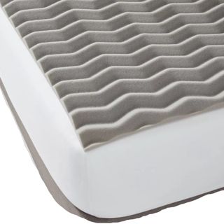 A gray mattress topper on a bed