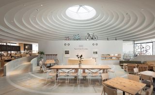 A cafe located within one of Nendo’s white concrete circular pavilions.