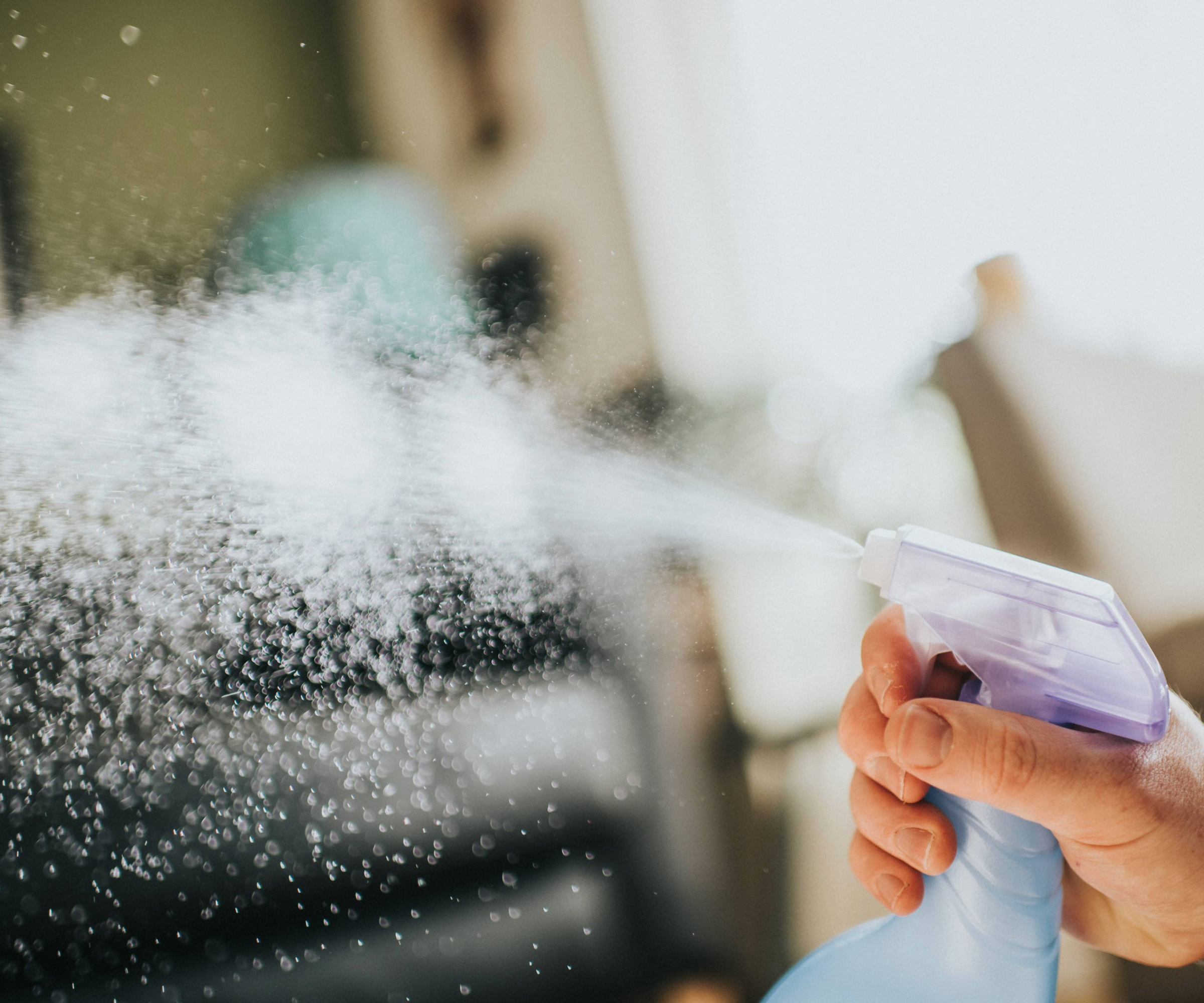 Hand spraying liquid from a bottle