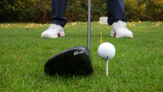 A golfer lining up to hit a driver