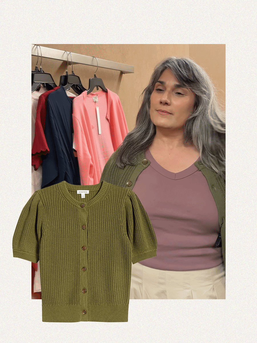 A woman with gray hair trying on a short-sleeve olive cardigan and mauve tee.