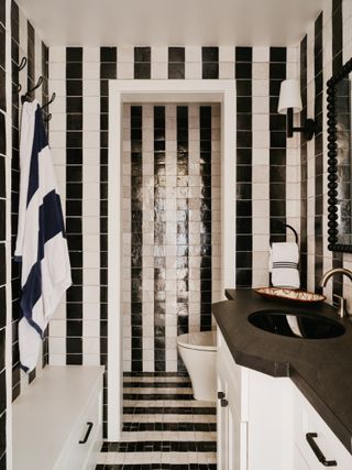 A bathroom completely covered with black and white tiles