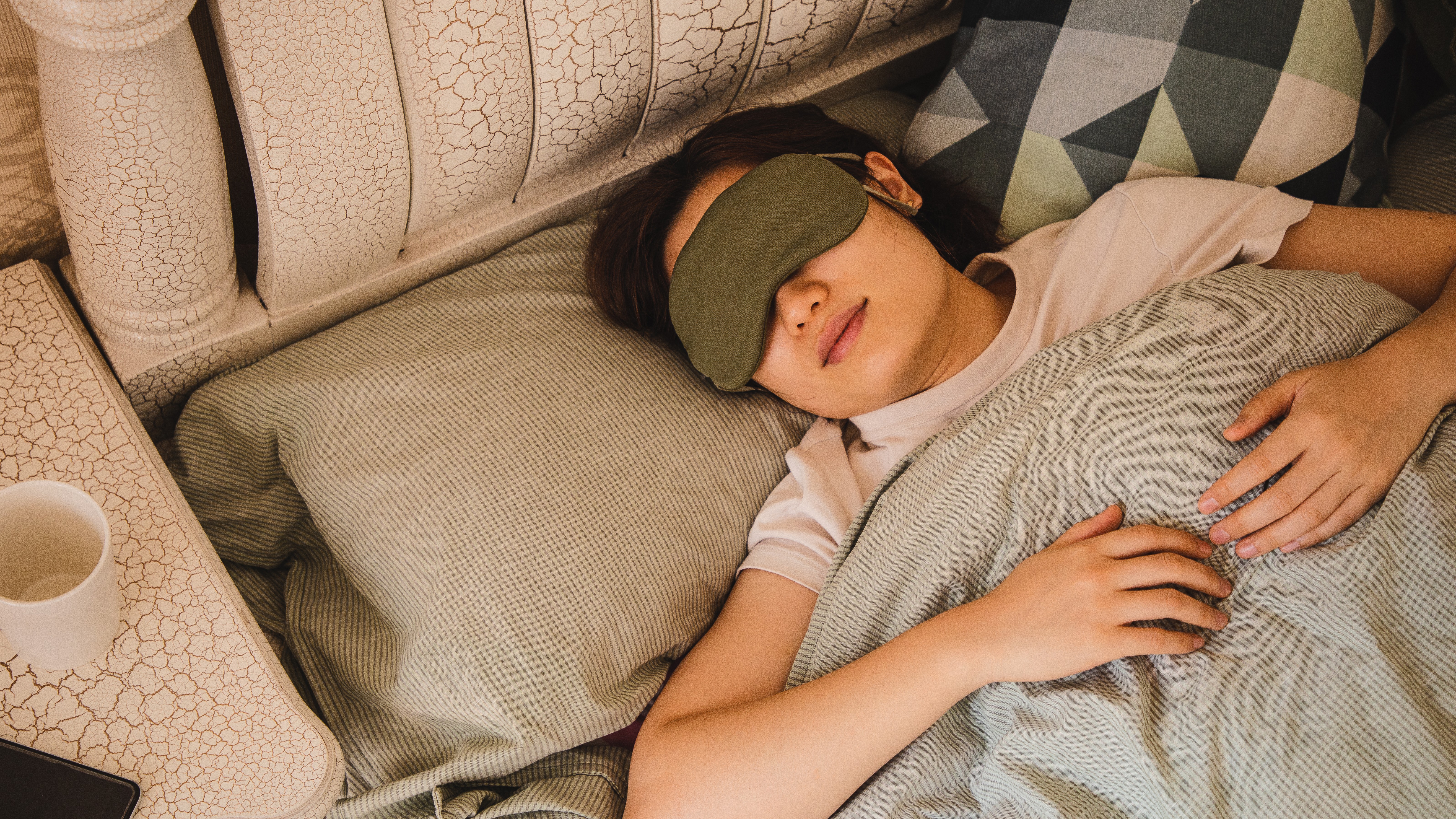 sleeping woman in bed wearing an eye mask