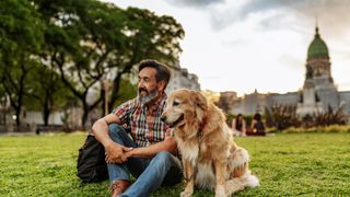Man sitting with dog on the grass