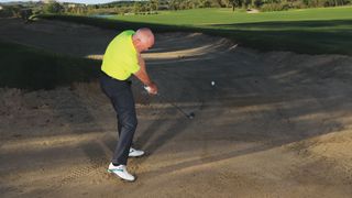 Keith Williams demonstrates how to hit a hybrid out of a fairway bunker