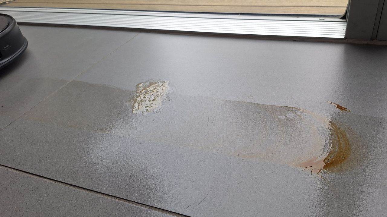 Honey and soy sauce smeared across a tiled floor, during the mopping test with the Roborock Saros 20