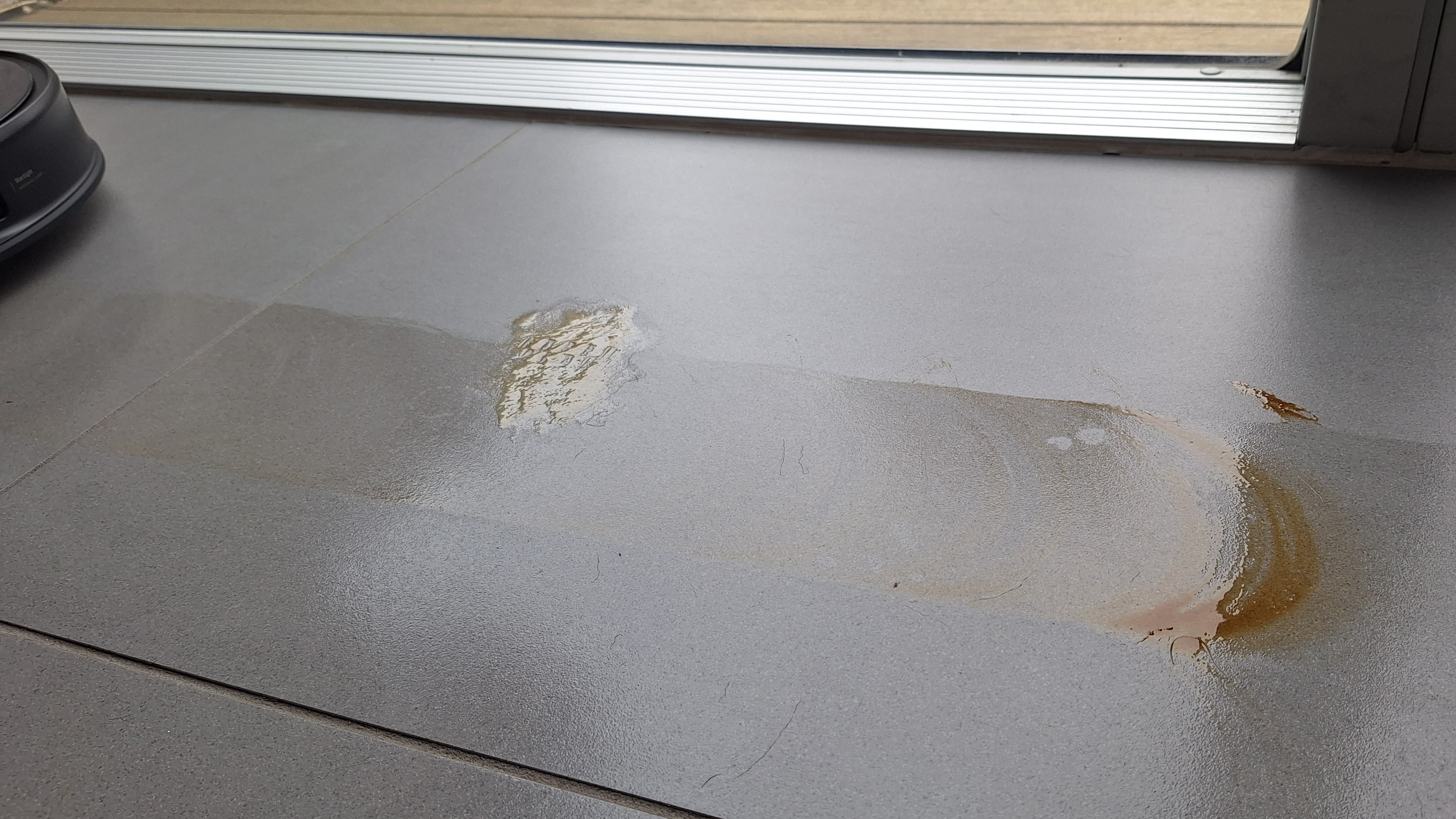 Honey and soy sauce smeared across a tiled floor, during the mopping test with the Roborock Saros 20
