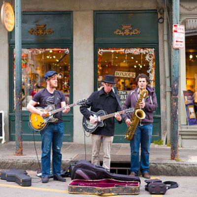 Jazz musicians saxophonist and guitarist in live busking performance on street corner in French Quarter, New Orleans