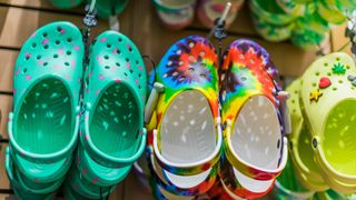 A wall of colorful Croc shoes being displayed in a store