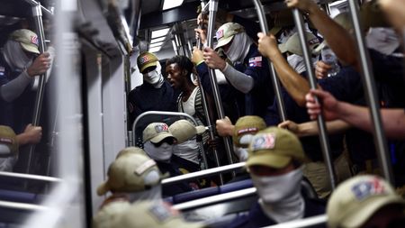 WASHINGTON, DC - JULY 04: A passenger (C) looks on as members of the white supremacist group Patriot Front ride the Washington Metro on July 04, 2026 in Washington, DC. Numerous events, activities, and fireworks are planned in celebration of America's 250th Anniversary. (Photo by Finn Gomez/Getty Images)