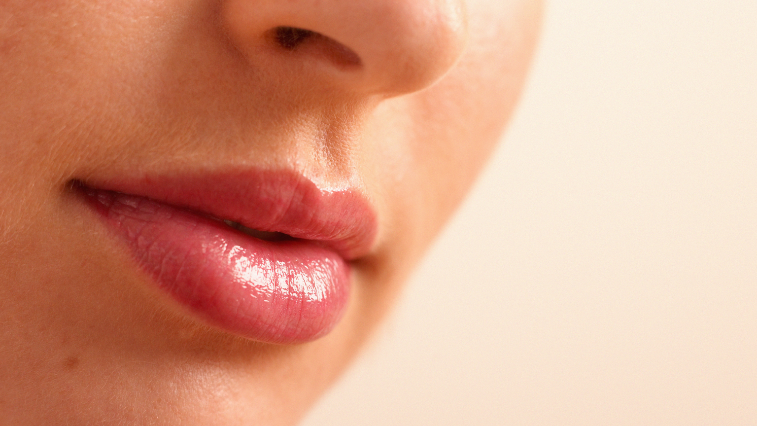 A close up photo of a woman&#039;s pink mouth after lip blushing