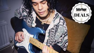 Man with long hair playing a blue Stratocaster