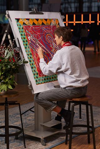 An artist creates a Hermes Carre scarf at its Carre Club exhibition in Paris