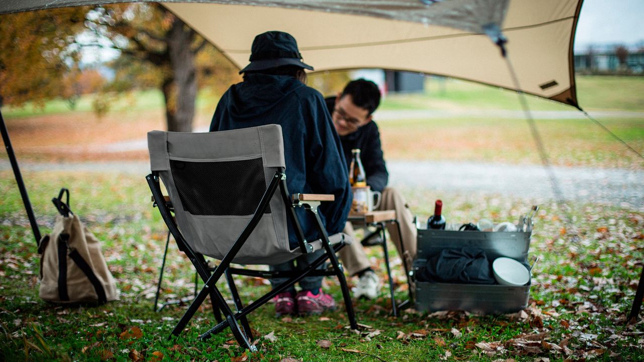 best camping chair: Snow Peak Beach Chair used under shelter