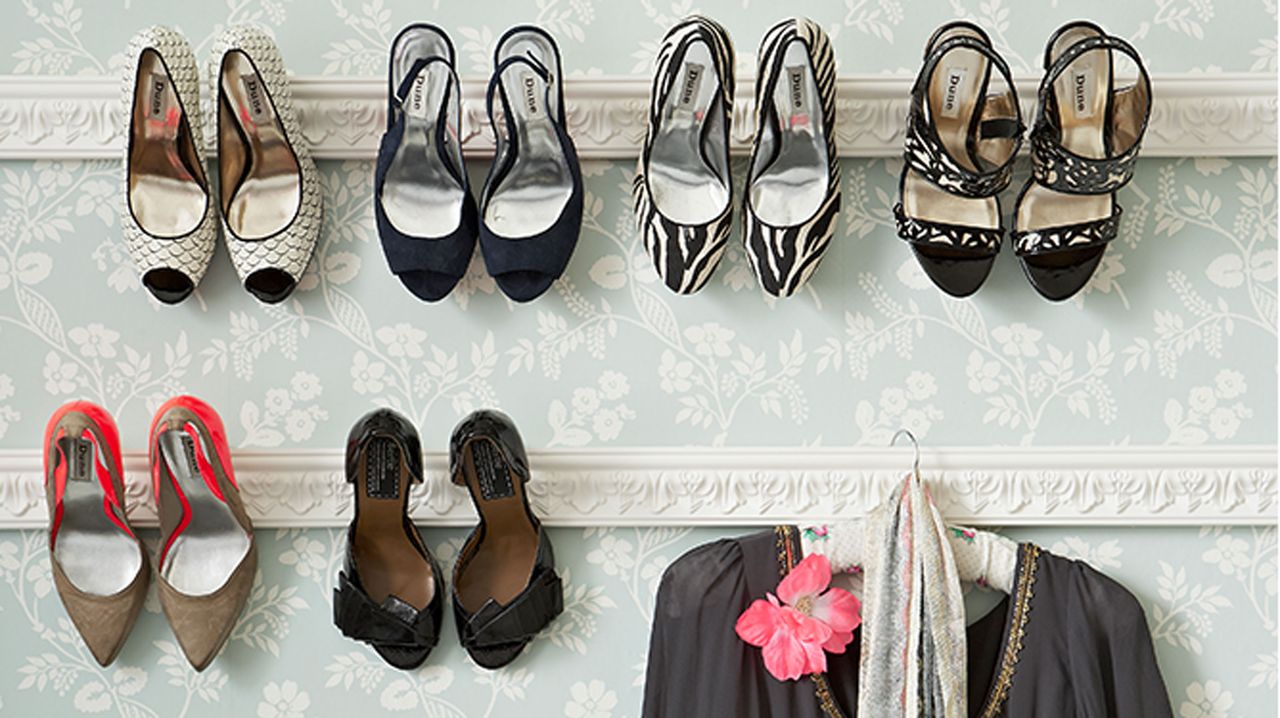 bedroom wall with white racks holding shoes