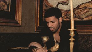 Drake stares into a golden goblet on the cover of his album Take Care. 