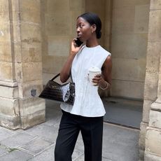 fashion influencer Sylvie Mus wearing a white peplum top and Toteme T-Lock handbag in brown croc-effect