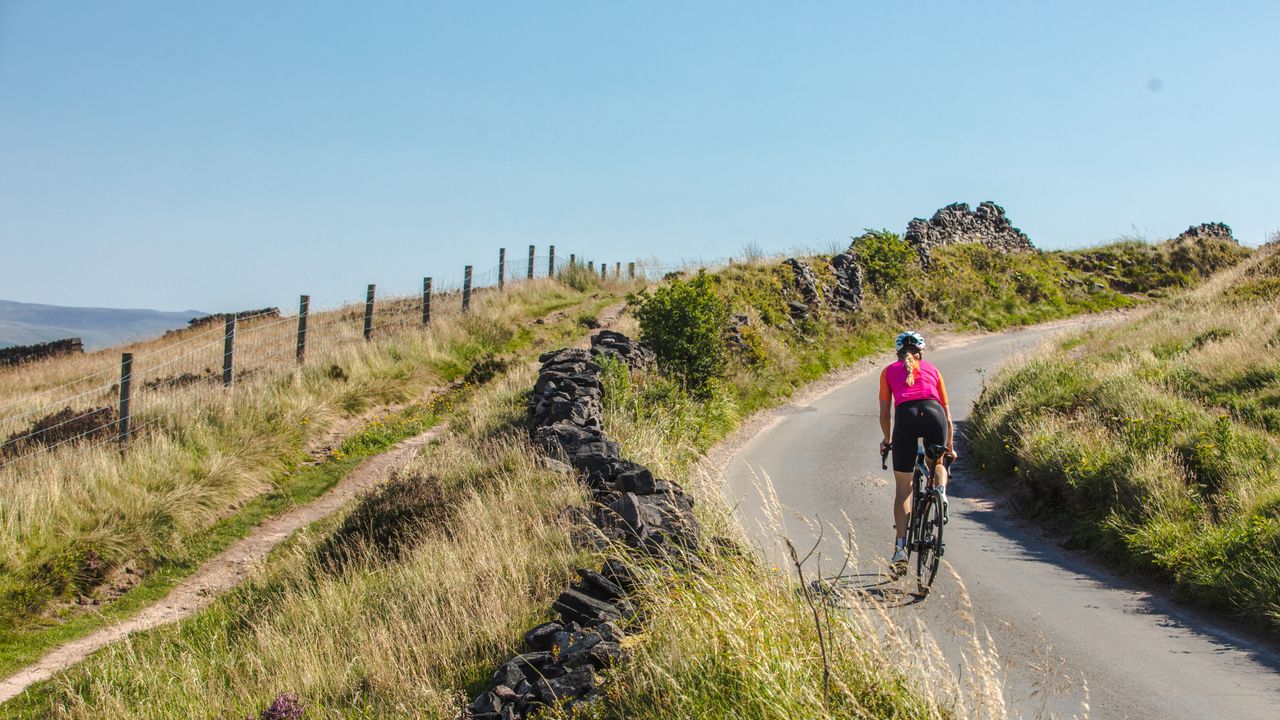 Image shows rider cycling in the sun.