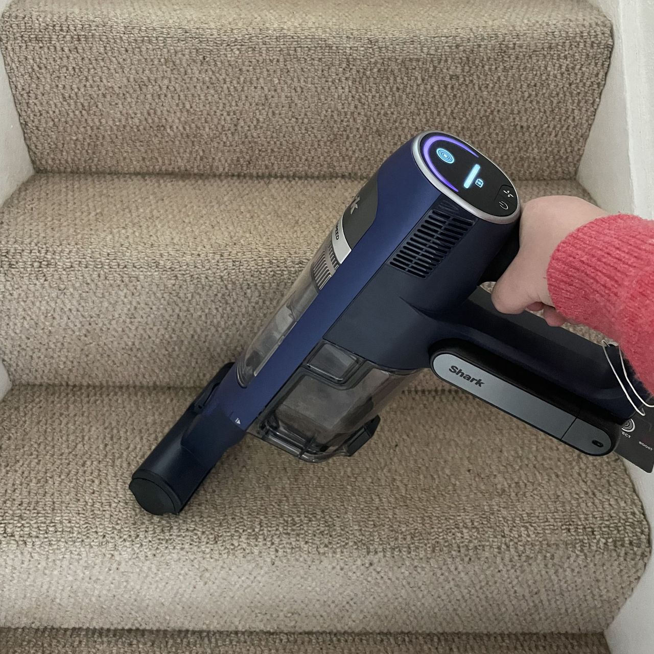 Using the Shark PowerDetect Speed in handheld mode to vacuum cream carpeted stairs