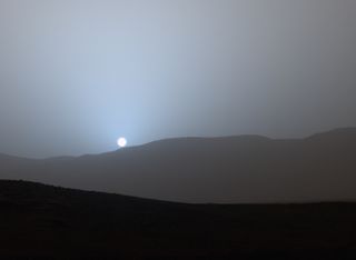 The sun sinks below the horizon in this stunning panoramic view captured by NASA&#039;s Spirit Mars rover in 2005. 