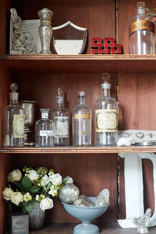 cabinet filled with glass bottles and other curios